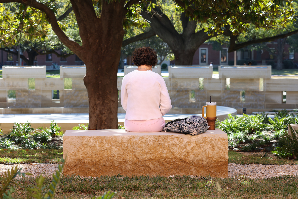 A person reads in front of Baylor's Memorial to Enslaved Persons